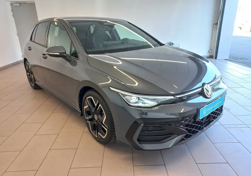 Volkswagen Golf 1.5 eTSI R-Line gris dauphin vue 3/4 avant droit en intérieur avec jantes spécifiques.
