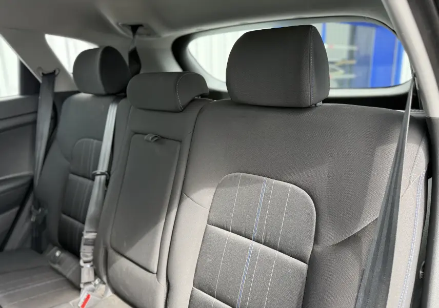 Vue rapprochée des sièges arrière en tissu gris foncé avec surpiqûres bleues du Hyundai Tucson 2015.