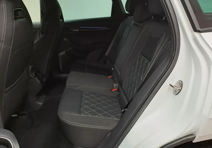 Vue intérieure côté droit sur les sièges arrière noirs avec surpiqûres en losange du Skoda Karoq Blanc Lune 2022 Sportline.