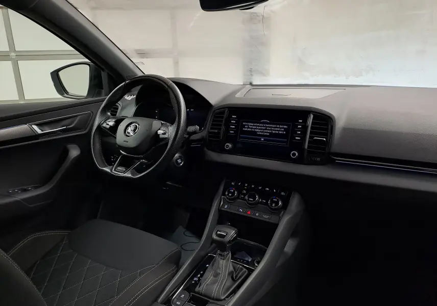 Intérieur du Skoda Karoq 2022 vue côté conducteur, tableau de bord noir avec écran tactile et levier de vitesse DSG7.