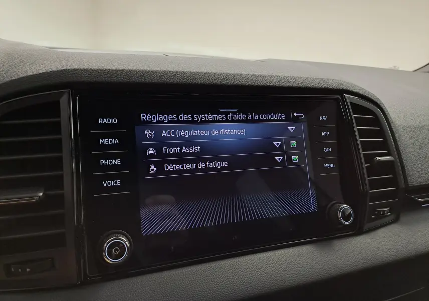 Écran central du tableau de bord du Skoda Karoq 2022 affichant les réglages d’aide à la conduite.