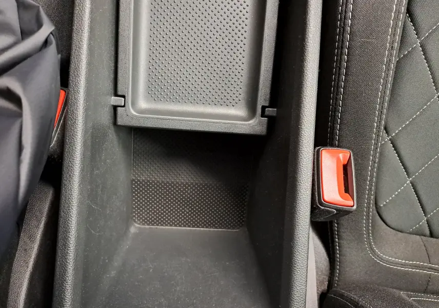 Gros plan sur la console centrale et la ceinture de sécurité côté droit du siège avant d’un Skoda Karoq Blanc Lune 2022.