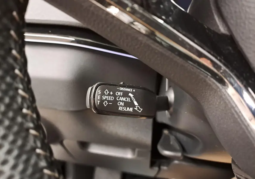 Gros plan sur la commande de régulateur de vitesse du Skoda Karoq 2.0 TDI 116 DSG7 Sportline, intérieur noir.