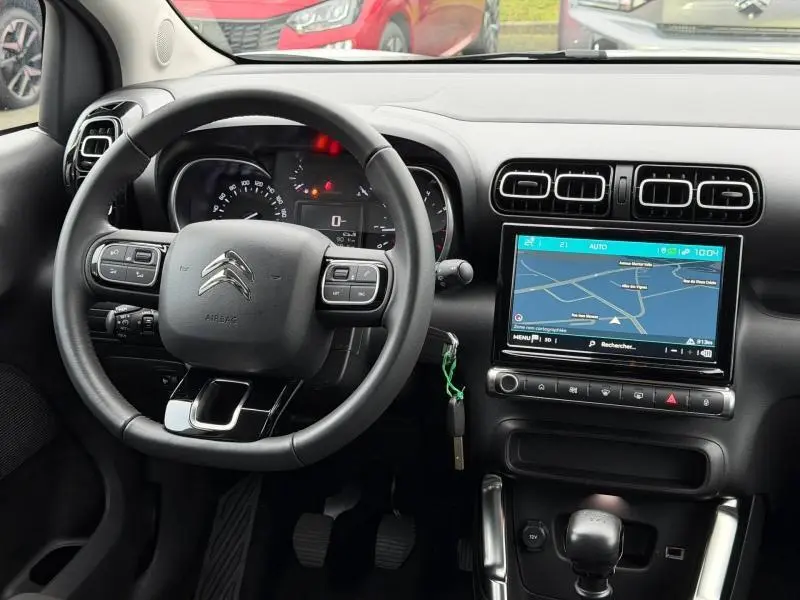 Vue intérieure du tableau de bord de la Citroën C3 Aircross 2024 avec volant cuir, écran tactile et commandes au volant.