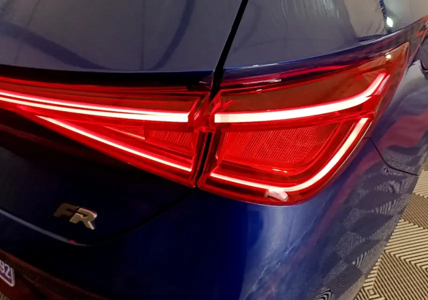 Feu arrière droit allumé sur SEAT Leon bleu 2021, version FR avec logo distinctif sur le hayon.