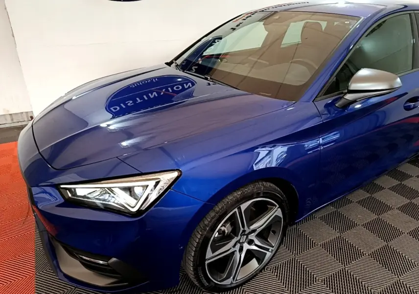 Vue 3/4 avant gauche d'une SEAT Leon bleu électrique avec phares LED et jantes alliage distinctives.