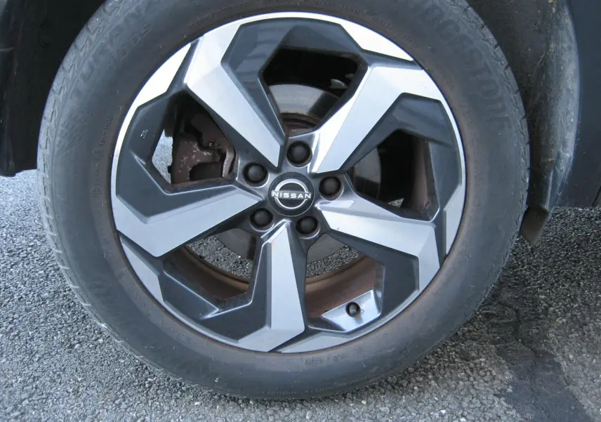 Gros plan sur la jante bi-ton noir et argent du Nissan Qashqai E-POWER 2024 avec logo central visible.