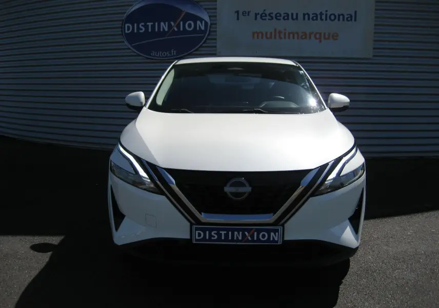 Vue frontale d'un Nissan Qashqai blanc nacré 2024 avec calandre noire et phares LED distinctifs.