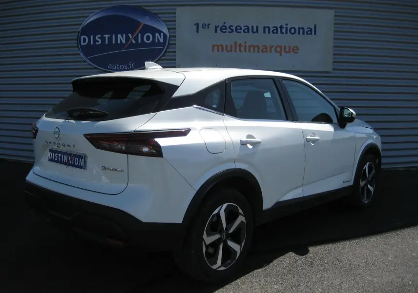 Vue 3/4 arrière droite du Nissan Qashqai blanc nacré E-POWER 2024 avec jantes bi-ton et feux LED distinctifs.