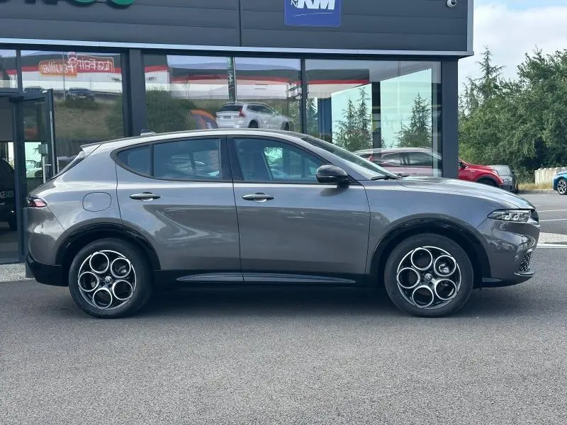 Vue de profil côté gauche d'une Alfa Romeo Tonale 1.5 Hybrid gris Vesuvio métallisé avec jantes alu distinctives.