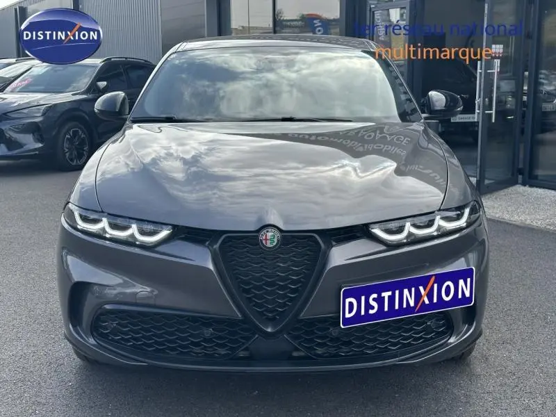 Vue frontale d'une Alfa Romeo Tonale 1.5 Hybrid gris Vesuvio métallisé avec calandre en V et feux LED distinctifs.