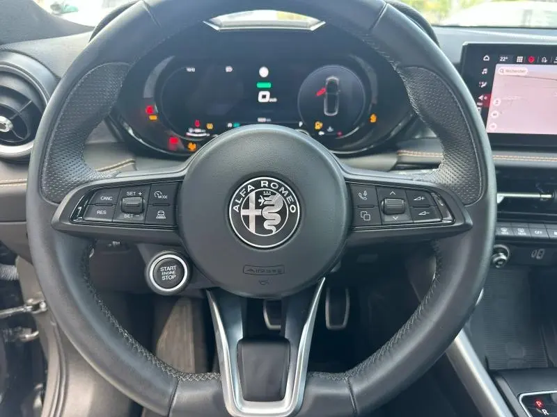 Volant cuir sport Alfa Romeo Tonale 2025 vu de face avec commandes intégrées et tableau de bord numérique.