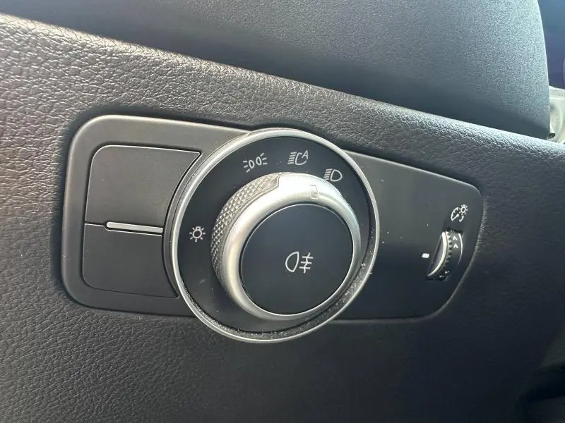 Gros plan sur la molette de réglage des phares de l'Alfa Romeo Tonale 1.5 Hybrid 130ch Sprint, finition noire texturée.