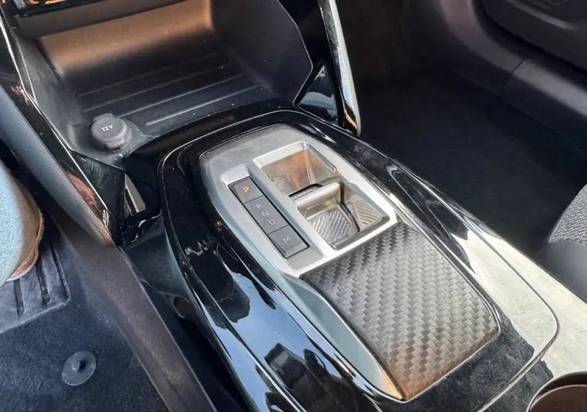 Gros plan sur la console centrale noire de la Peugeot 2008 Hybrid 136 e-DCS6 Allure avec levier de vitesses automatique.