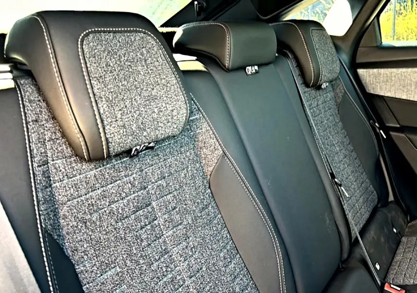 Vue rapprochée des sièges arrière en tissu gris et cuir noir du Peugeot 3008 2025, version hybride allure.