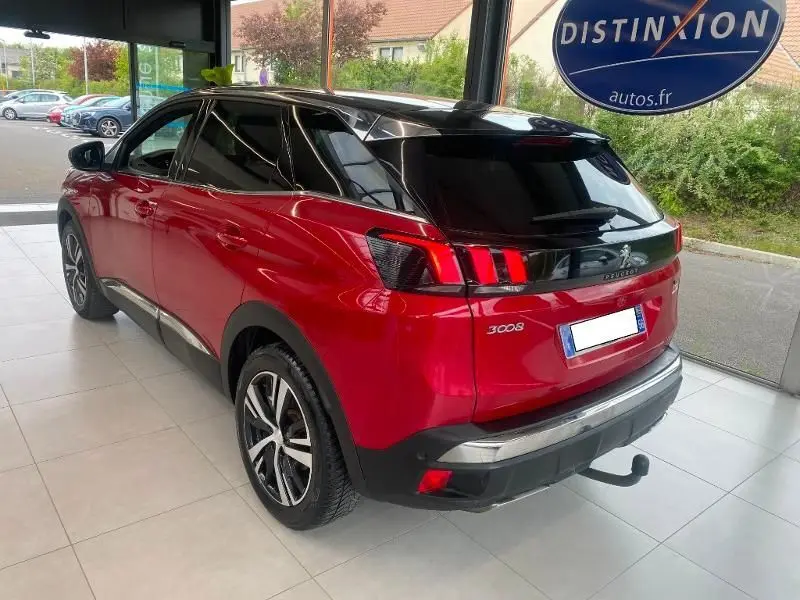 Vue 3/4 arrière droite d'un Peugeot 3008 rouge 2018 GT Line avec feux arrière à griffes et attelage visible.