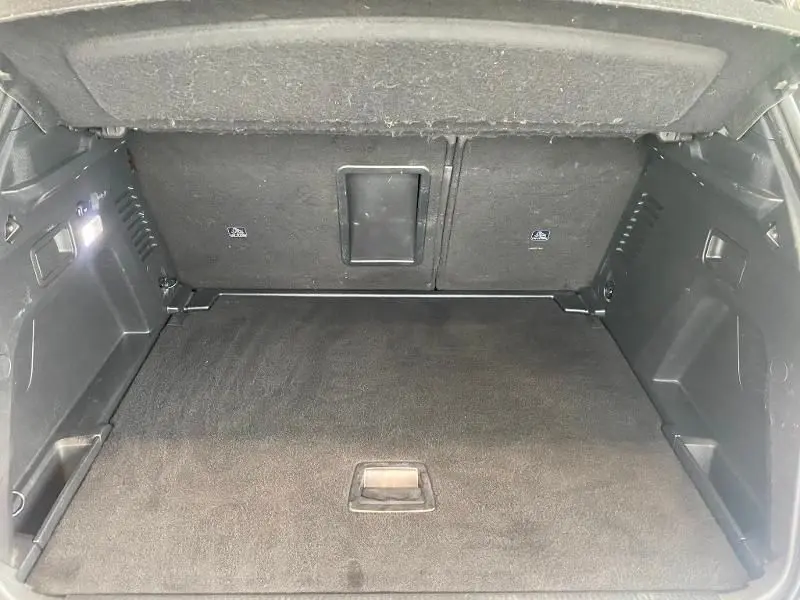 Coffre ouvert du Peugeot 3008 rouge 2018, vue intérieure montrant un espace de chargement propre et spacieux.