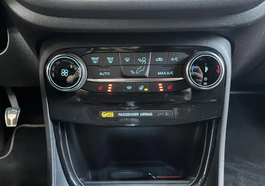 Vue rapprochée de la console centrale du Ford Puma gris 2023, avec commandes climatisation et sièges chauffants activés.