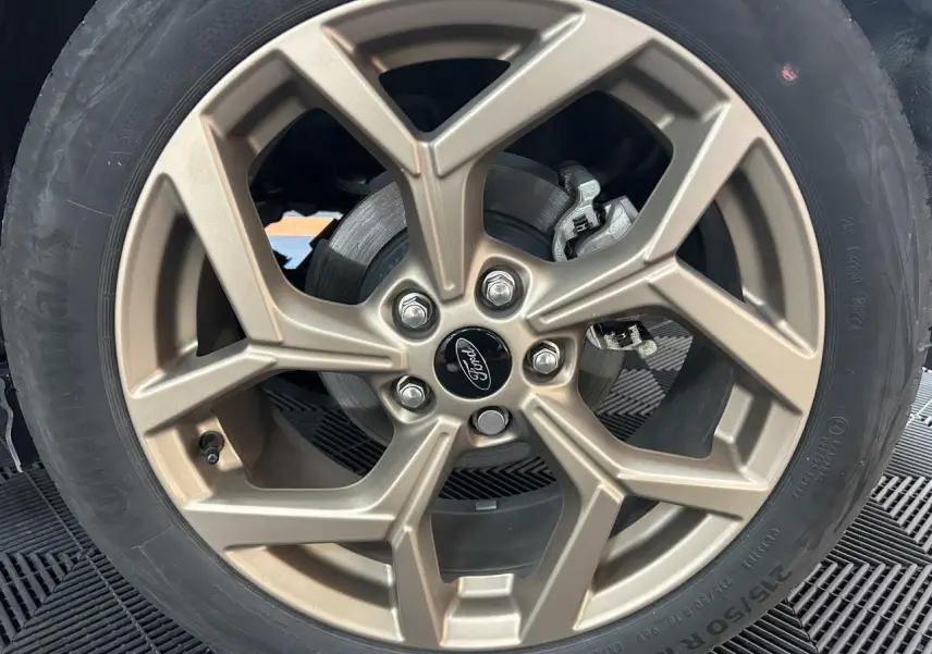 Gros plan sur la jante alliage 18 pouces finition Gold du Ford Puma gris, mettant en valeur le logo central Ford.