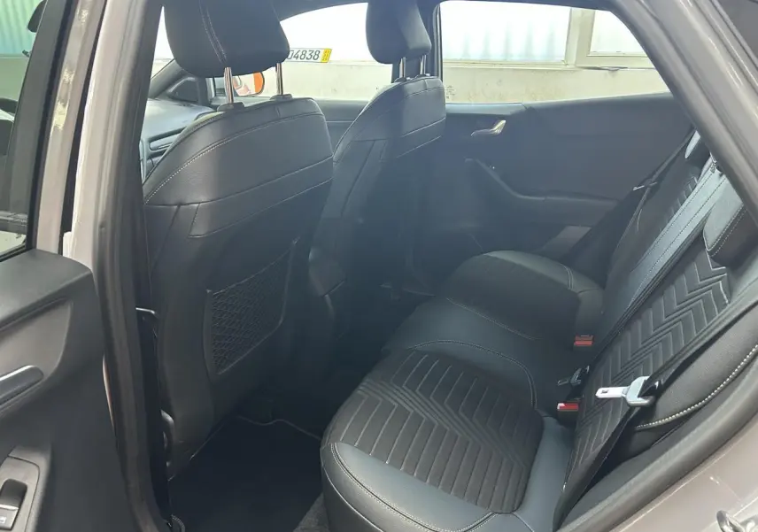 Vue intérieure arrière côté gauche du Ford Puma gris 2023, sièges arrière en cuir et tissu noir avec surpiqûres.