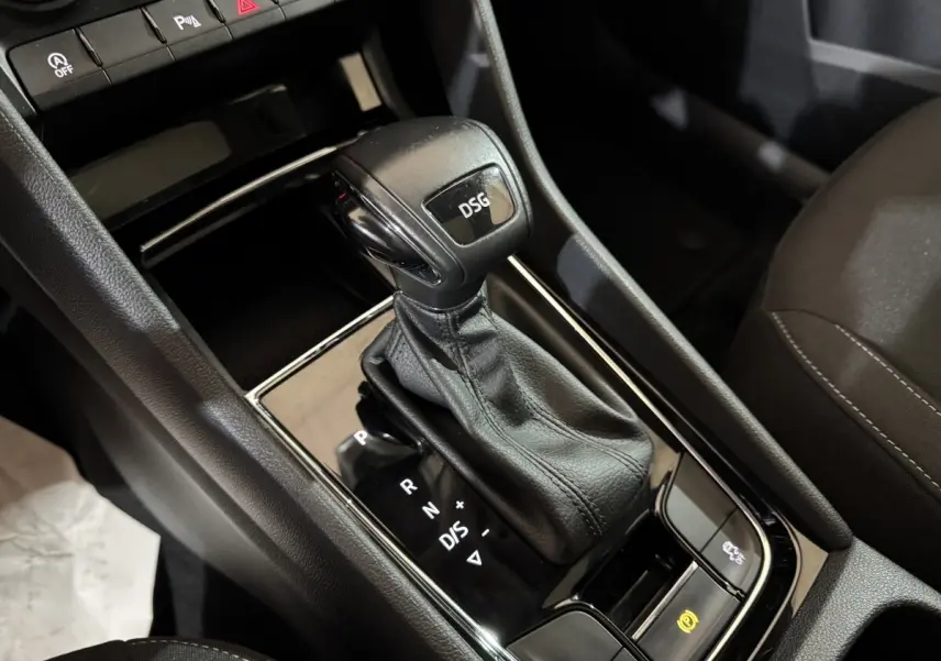 Le levier de vitesses DSG noir en gros plan sur la console centrale intérieure d'un Skoda Karoq blanc.