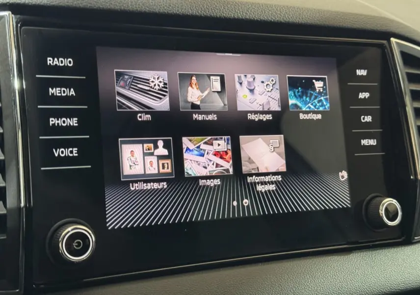 Écran tactile central du Skoda Karoq 1.5 TSI blanc, affichant les menus climatisation, manuels et réglages.