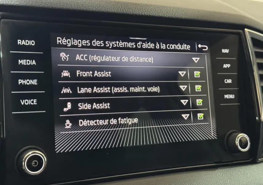 Écran tactile central du Skoda Karoq blanc 2021 affichant les réglages d'aide à la conduite