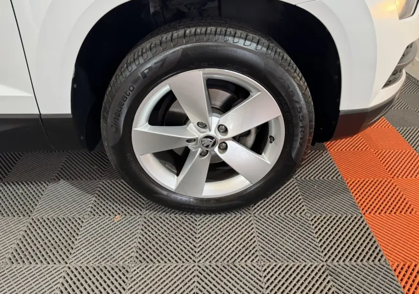 Gros plan sur la roue avant gauche blanche d'un Skoda Karoq 1.5 TSI 2021 avec jante alliage cinq branches.