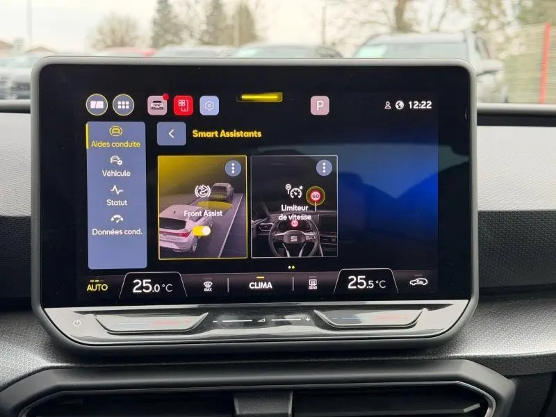 Écran tactile central du tableau de bord du SEAT LEON 2025 affichant les assistants de conduite, avec commandes climatisation visibles.