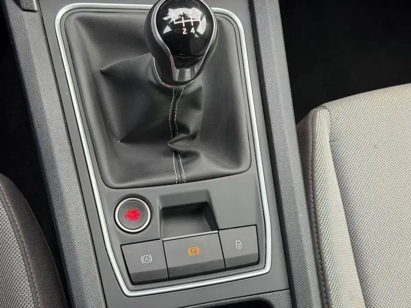 Gros plan sur la console centrale noire du SEAT LEON 2025 avec levier de vitesses manuel et boutons de contrôle.