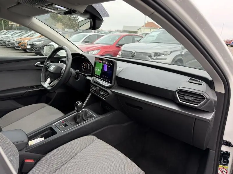 Vue intérieure côté conducteur de la SEAT LEON 2.0 TDI 115ch STYLE XL 2025, avec tableau de bord noir et écran tactile central.