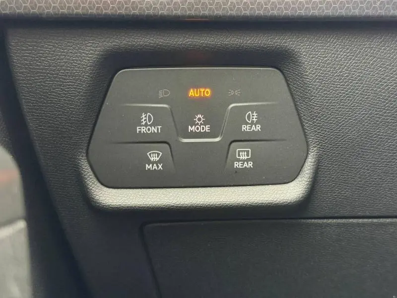 Gros plan sur les commandes d’éclairage et de dégivrage du tableau de bord noir du SEAT LEON 2.0 TDI 115ch STYLE XL 2025.