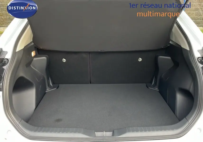 Coffre ouvert vu de l'arrière d'une Toyota Yaris Cross blanc pur, montrant un espace de chargement propre et spacieux.