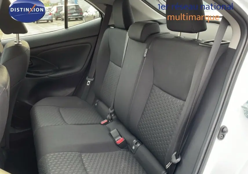 Vue intérieure côté droit montrant les sièges arrière noirs en tissu de la Toyota Yaris Cross 2024 blanche.