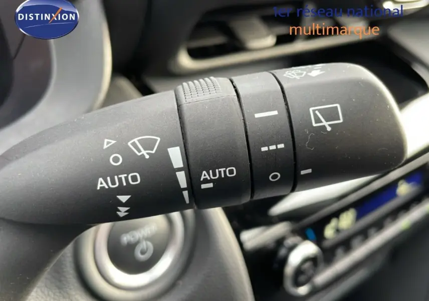 Gros plan sur la commande d'essuie-glace automatique à gauche du volant dans le Toyota Yaris Cross blanc pur 2024.