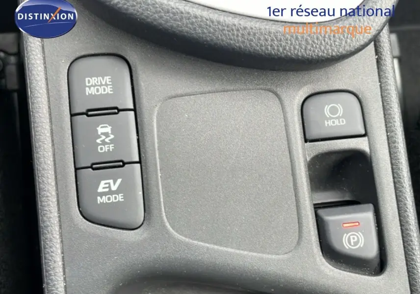 Gros plan sur la console centrale de la Toyota Yaris Cross blanche, montrant les boutons Drive Mode, EV Mode et frein à main électronique.