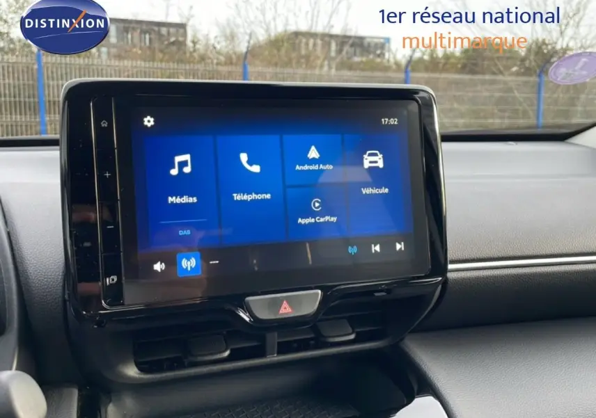 Écran tactile central de la Toyota Yaris Cross blanc pur, vue de face sur le tableau de bord avec interface multimédia visible.