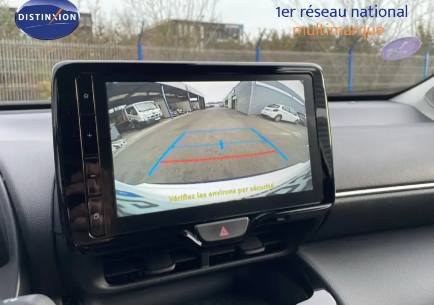 Vue intérieure du tableau de bord de la Toyota Yaris Cross 2024, écran affichant la caméra de recul avec repères colorés.