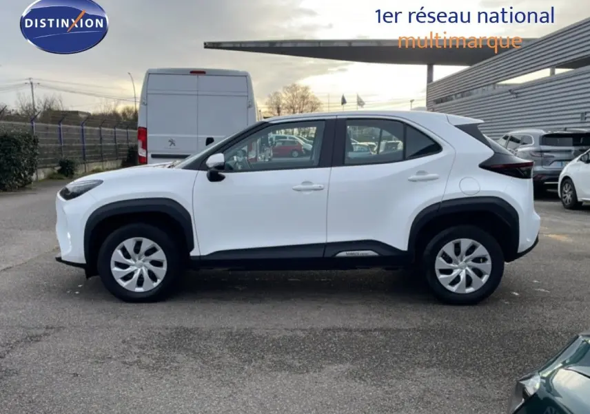 Vue latérale droite d'une Toyota Yaris Cross blanche pure 2024 avec protections noires et jantes acier.