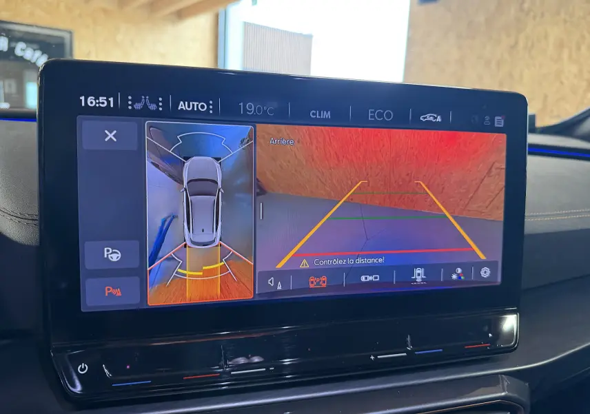 Écran tactile intérieur montrant la caméra 360° et vue arrière du CUPRA Formentor gris clair, avec interface de stationnement.