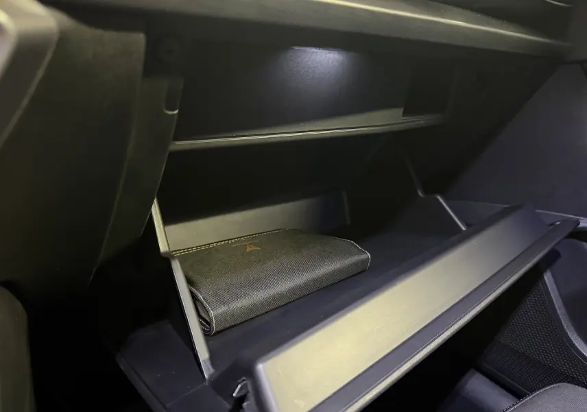 Gant de rangement ouvert côté passager montrant un livret noir dans l’habitacle sombre du CUPRA Formentor hybride 2023.