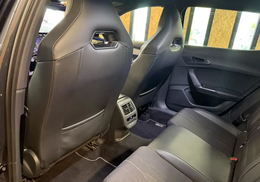 Vue arrière intérieure du CUPRA Formentor 1.4 Hybrid 245 DSG6 VZ 2023, sièges noirs en cuir et tissu, console centrale avec aérateurs.