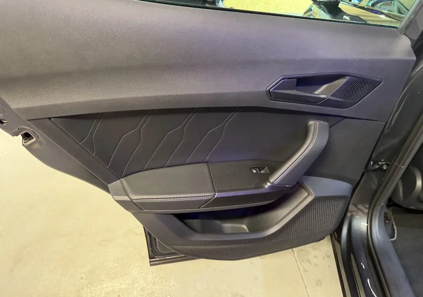 Vue rapprochée de la porte avant gauche noire du CUPRA Formentor 2023 avec surpiqûres apparentes et poignée intégrée.