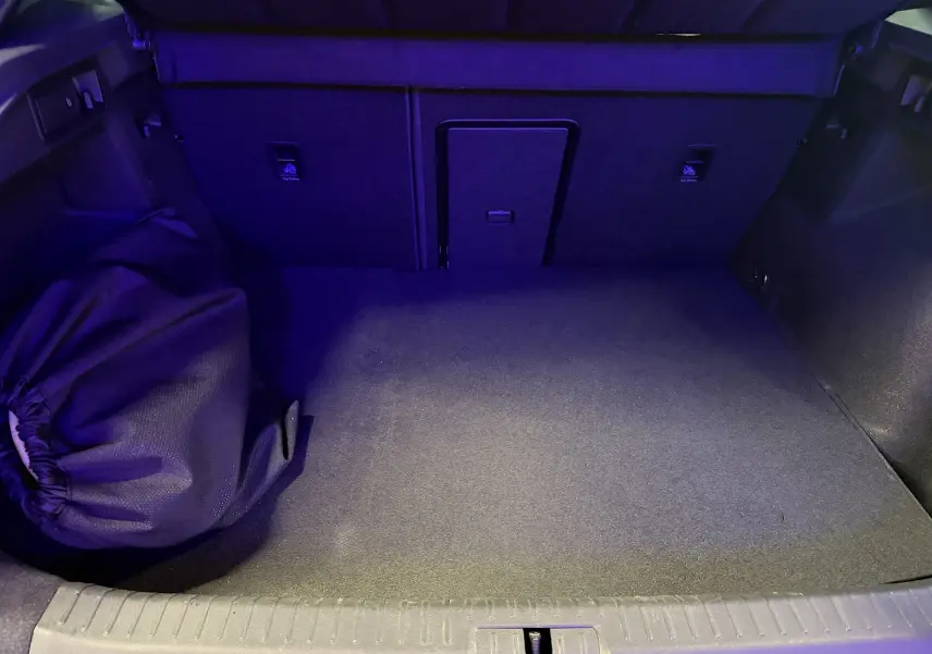 Vue intérieure du coffre du CUPRA Formentor gris clair 2023, montrant l'espace de chargement avec un sac noir sur le côté gauche.