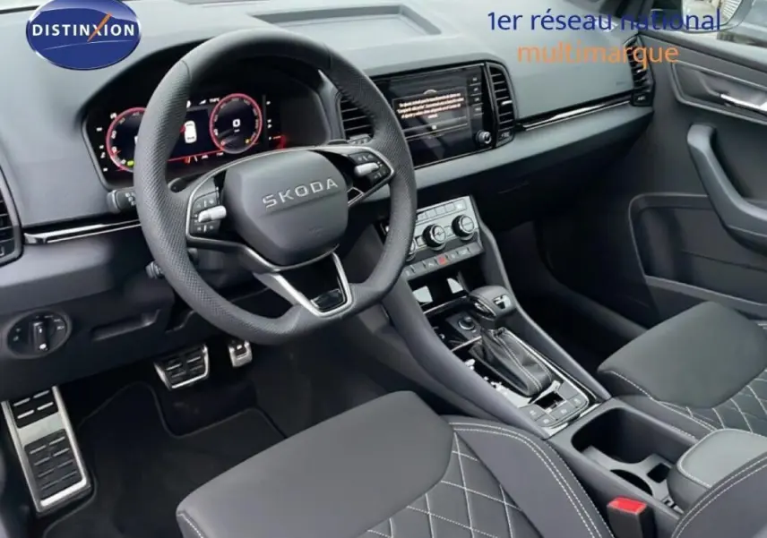 Vue intérieure du poste de conduite du Skoda Karoq argent 2025, volant cuir multifonctions et écran tactile central.