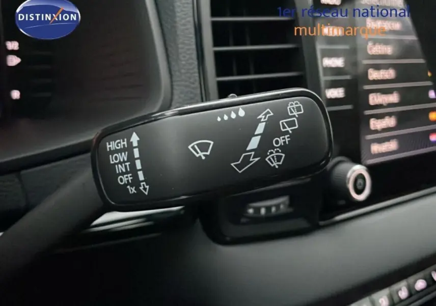 Gros plan sur la commande des essuie-glaces dans l’habitacle d’un Skoda Karoq argent 2025, écran tactile en arrière-plan.