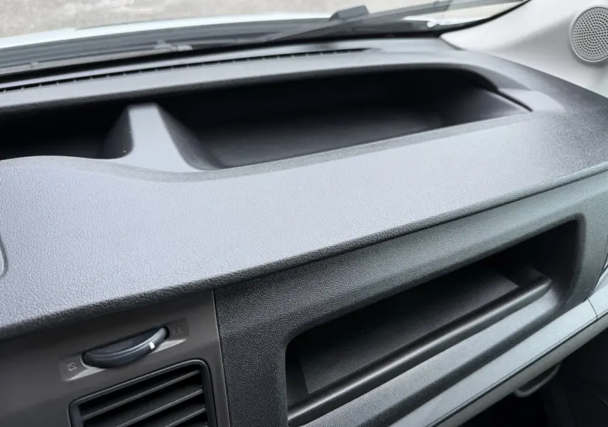 Détail de la planche de bord noire du Ford Transit Fourgon blanc, vue intérieure côté passager.