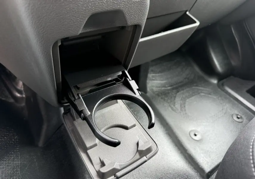 Gros plan sur le porte-gobelet déplié côté passager dans l'habitacle gris foncé du Ford Transit Fourgon blanc.