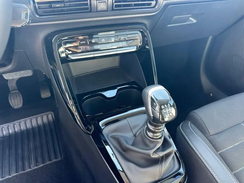 Gros plan sur la console centrale intérieure de la Citroën C3 2025, montrant le levier de vitesse manuel et les commandes de climatisation.