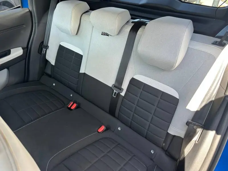 Vue intérieure de la banquette arrière bicolore noire et grise de la Citroën C3 2025 avec ceintures et appuie-têtes visibles.